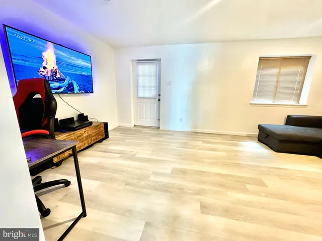 a bedroom with a bed and a potted plant on the dresser