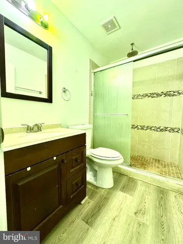 a bathroom with a sink mirror toilet and next to a window