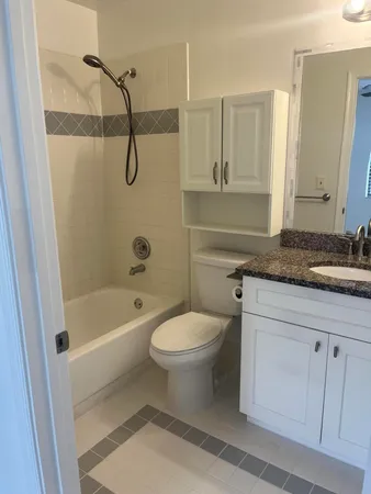 a bathroom with a granite countertop sink a toilet and shower
