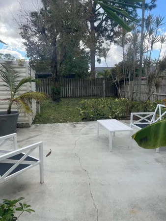 a view of a backyard with sitting area and tree