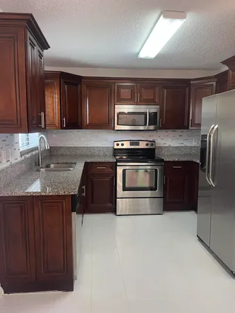 a kitchen with stainless steel appliances granite countertop a sink a stove a microwave and island