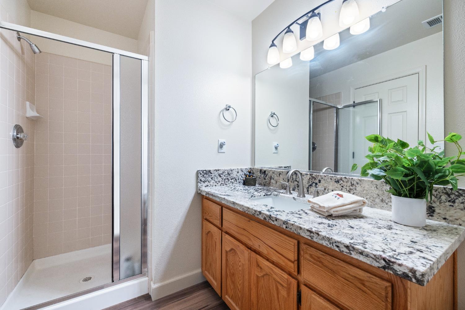 39398 Robin Bass Lake, CA 93604 - Photo 20 of 31 a bathroom with a granite countertop sink and a mirror