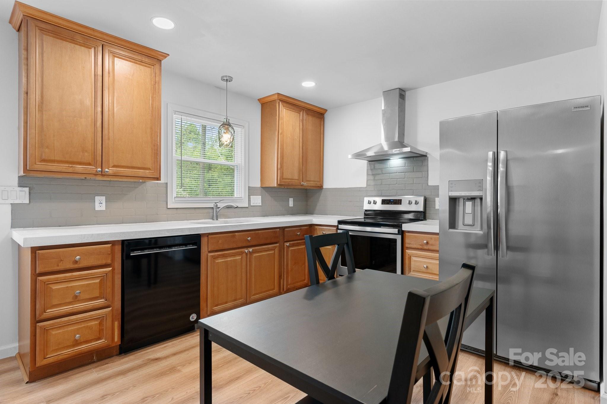 2473 Israel Chapel Road Connelly Springs, NC 28612 - Photo 10 of 37 a kitchen with a refrigerator a stove a sink and dishwasher with wooden floor