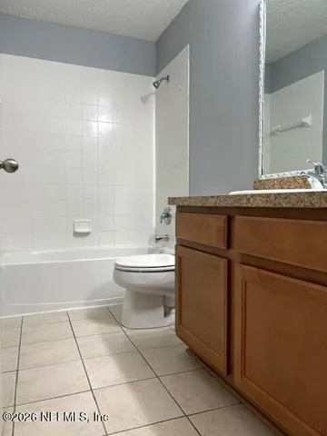 a bathroom with a granite countertop toilet a sink and a mirror