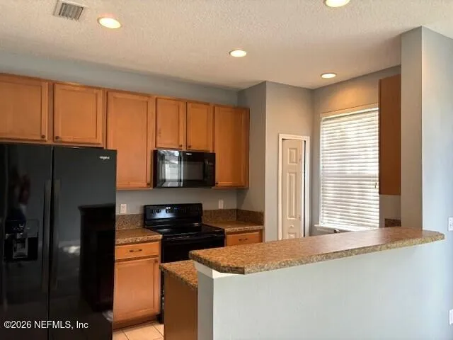 a kitchen with stainless steel appliances granite countertop a refrigerator a stove and a sink with wooden floor