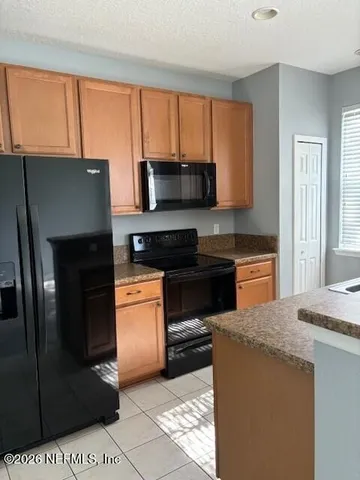 a kitchen with stainless steel appliances kitchen island granite countertop a stove a sink and a microwave