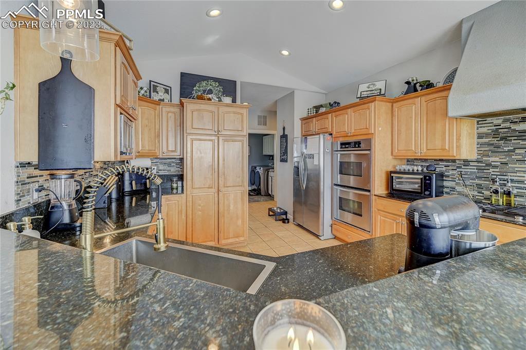 8640 Berridge Road Calhan, CO 80808 - Photo 14 of 50 a kitchen with stainless steel appliances granite countertop a refrigerator a stove and a sink