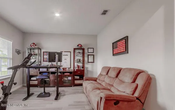 a living room with furniture a flat screen tv and a floor to ceiling window
