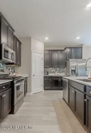 a kitchen with stainless steel appliances kitchen island granite countertop a sink and cabinets