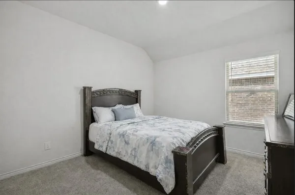 a bed sitting in a bedroom next to a window