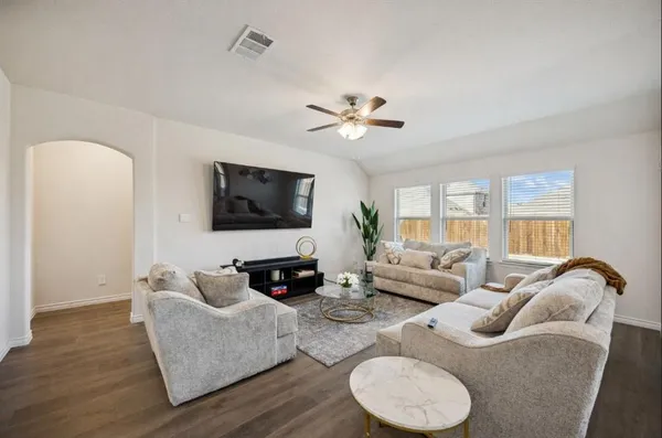 a living room with furniture ceiling fan and a flat screen tv