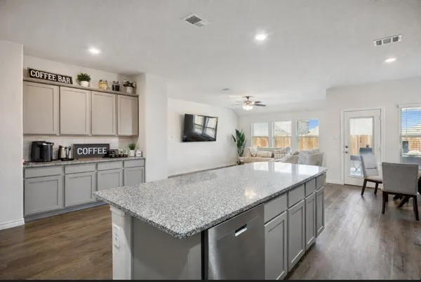 a kitchen with granite countertop cabinets a sink a counter space and stainless steel appliances