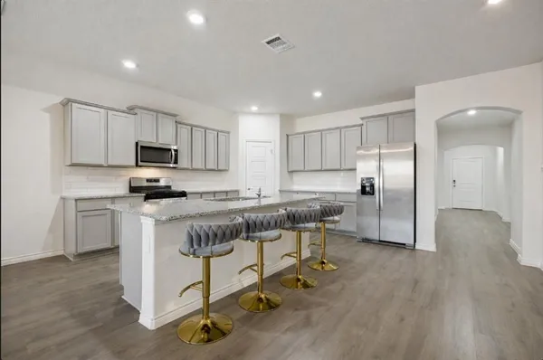 a kitchen with a refrigerator a sink and cabinets