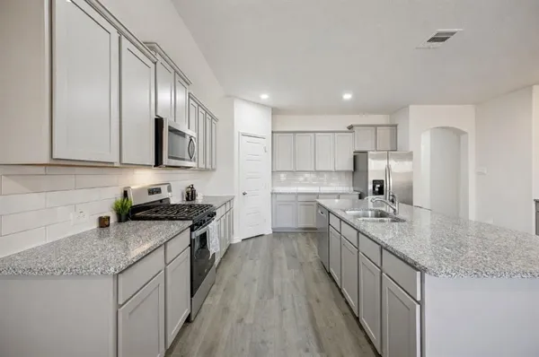 a kitchen with stainless steel appliances granite countertop a sink stove and refrigerator