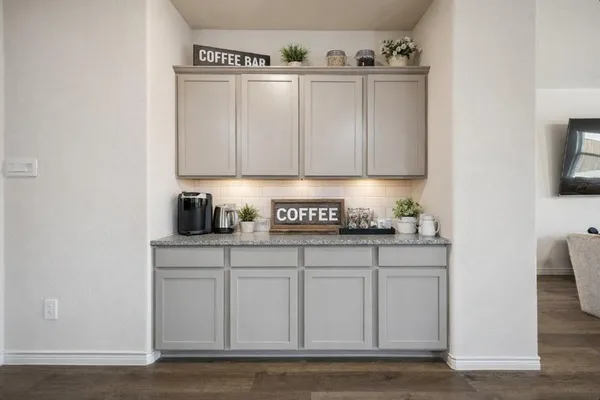 a kitchen with granite countertop white cabinets and sink
