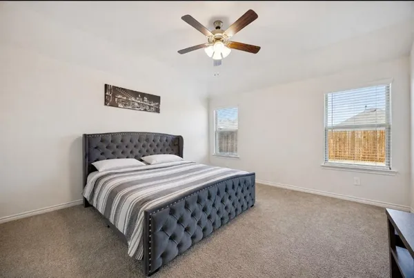 a bedroom with a bed chandelier and a window