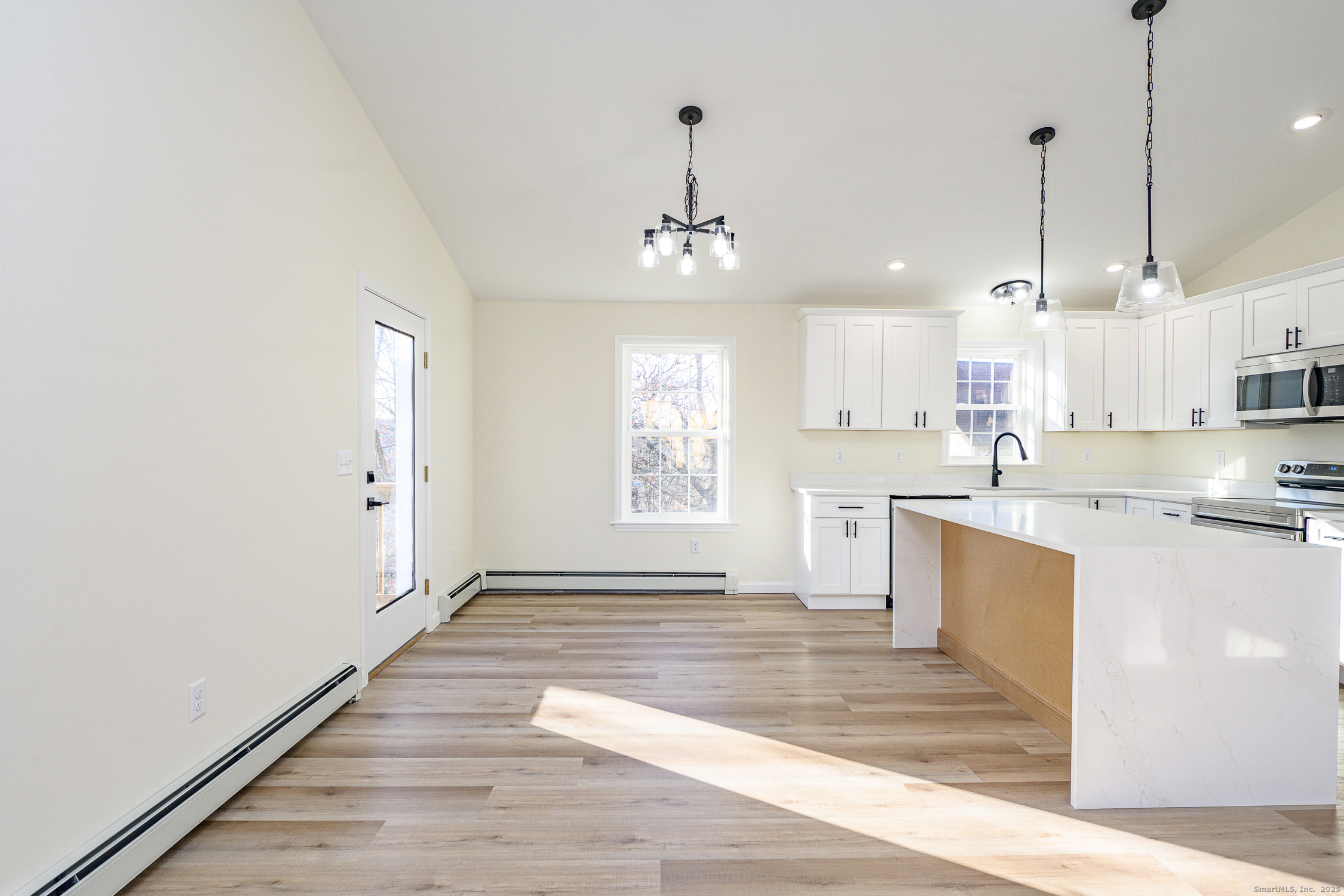 6 Prospect Street Putnam, CT 06260 - Photo 17 of 40 a large kitchen with granite countertop a stove a sink dishwasher a refrigerator and white cabinets with wooden floor