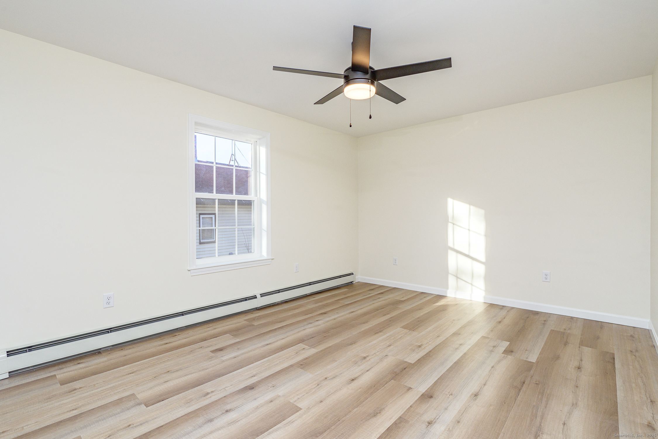 6 Prospect Street Putnam, CT 06260 - Photo 22 of 40 an empty room with wooden floor fan and windows