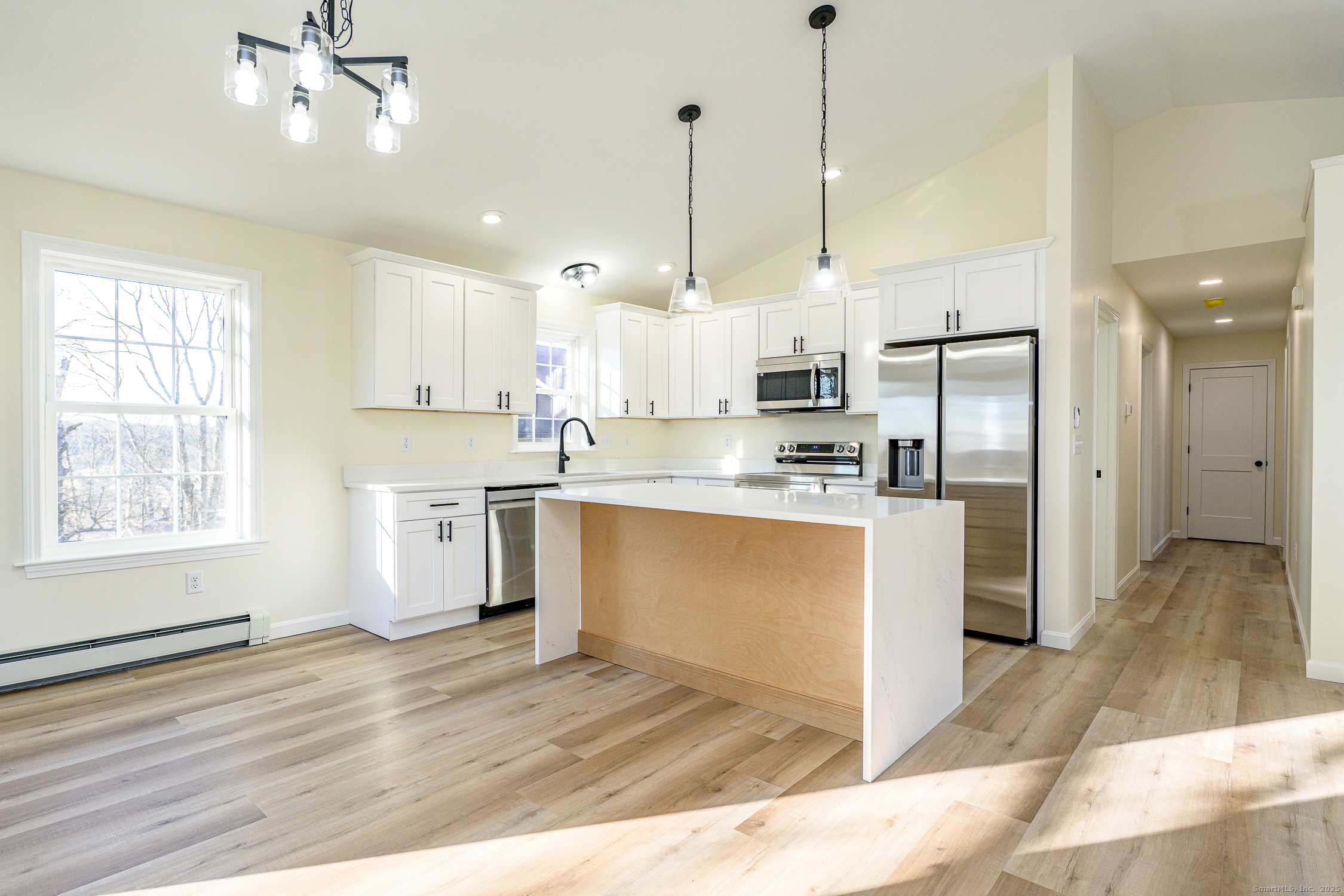 6 Prospect Street Putnam, CT 06260 - Photo 6 of 40 a kitchen with stainless steel appliances granite countertop a refrigerator a sink dishwasher a stove and white cabinets with wooden floor