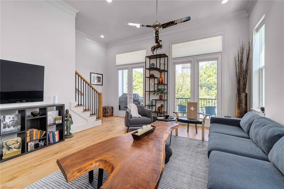 a living room with furniture a flat screen tv and a large window