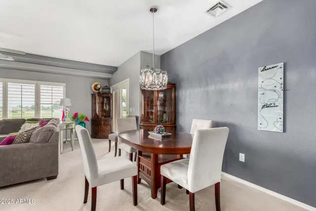 a view of a dining room with furniture and chandelier