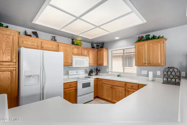 a kitchen with stainless steel appliances granite countertop a sink a stove and refrigerator