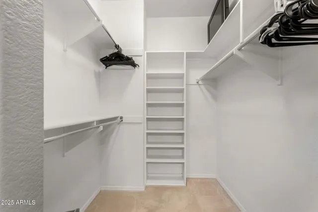 a view of walk in closet with empty racks