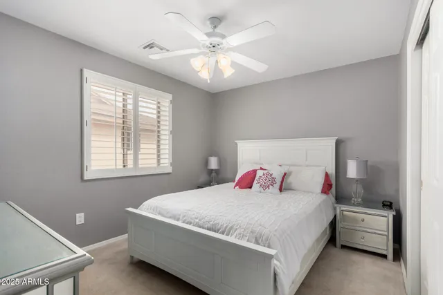 a bedroom with a large bed and a ceiling fan