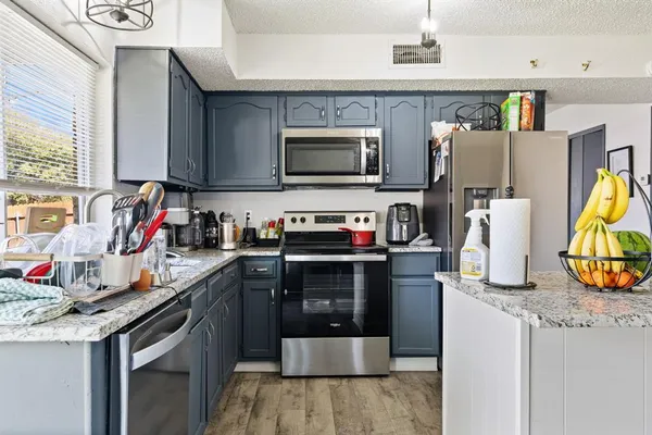 a kitchen with stainless steel appliances granite countertop a refrigerator and a sink