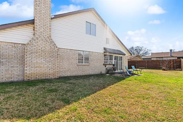 a view of a house with backyard and fence