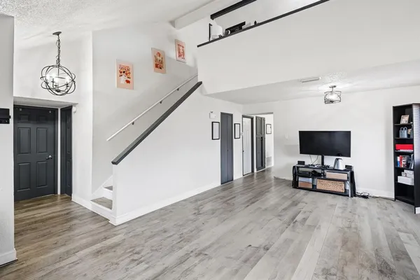 a view of empty room with wooden floor and window