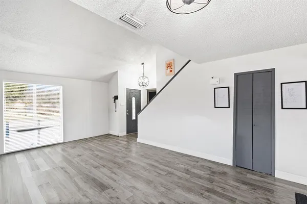 a view of an empty room with a window and fireplace