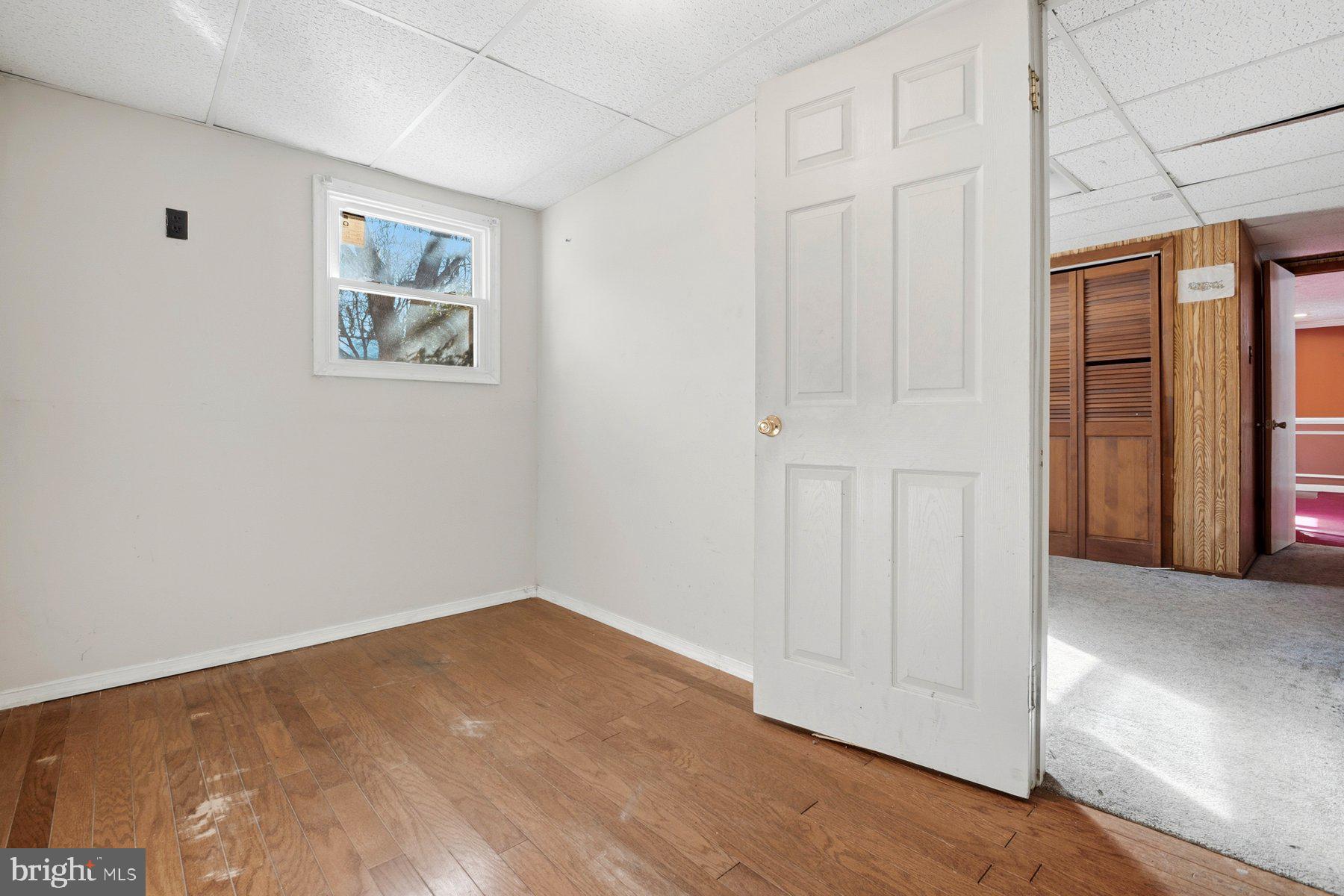 7526 Lemon Tree Court Hanover, MD 21076 - Photo 25 of 27 an empty room with wooden floor and windows