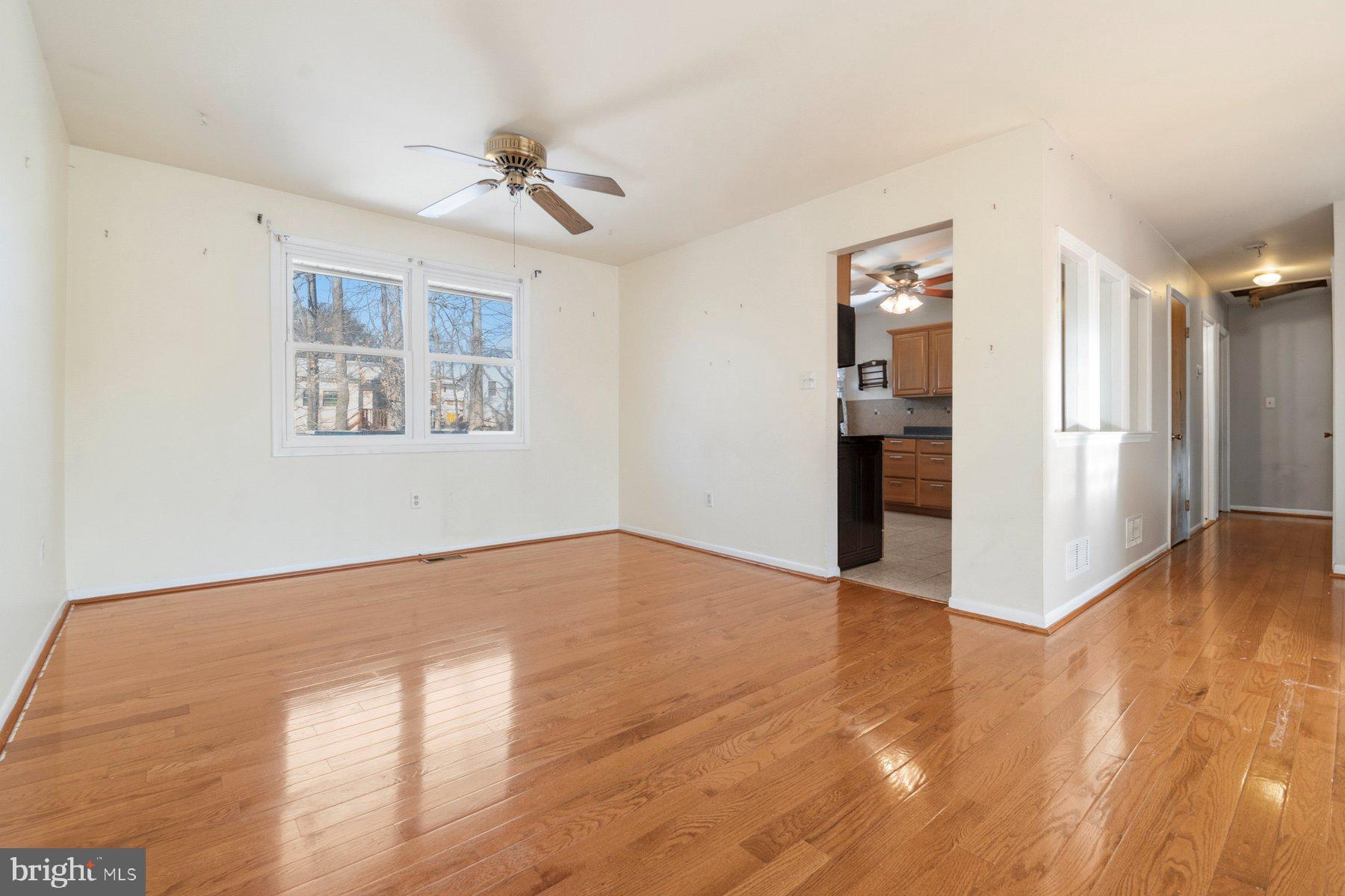 7526 Lemon Tree Court Hanover, MD 21076 - Photo 5 of 27 a view of an empty room with a window and wooden floor