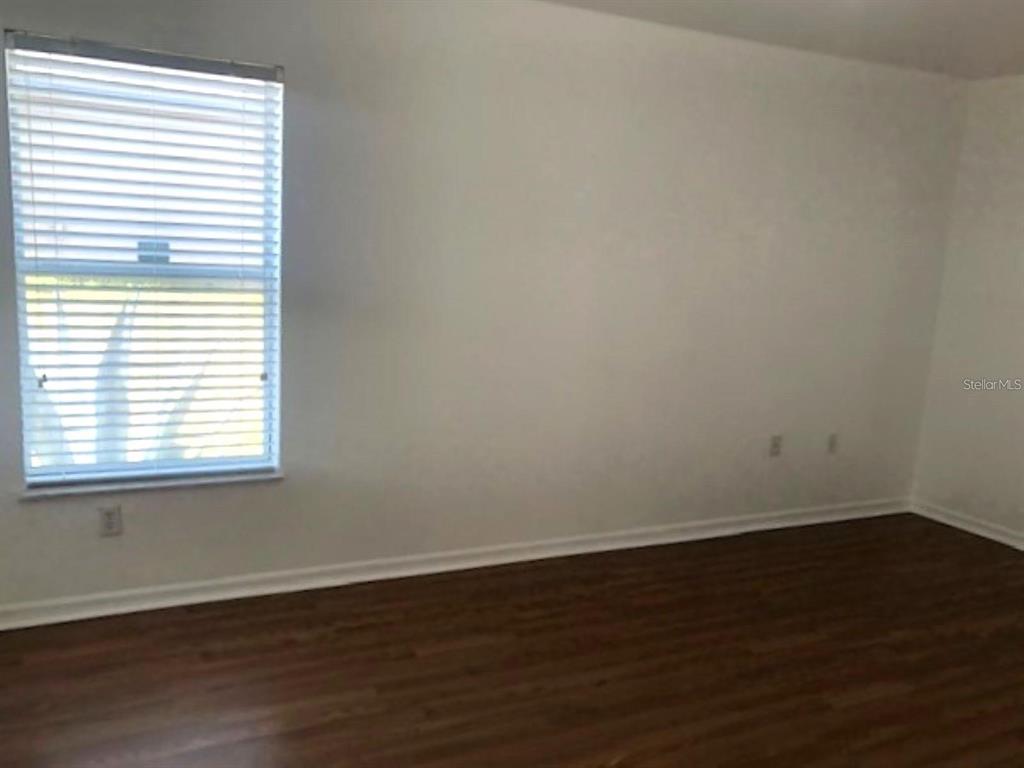 4955 Southwest 129th Place Ocala, FL 34473 - Photo 11 of 19 an empty room with wooden floor and a window