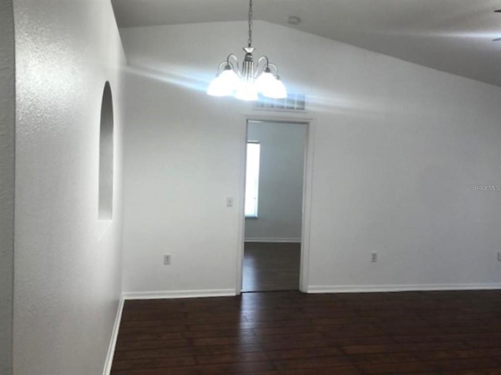 4955 Southwest 129th Place Ocala, FL 34473 - Photo 9 of 19 an empty room with wooden floor and windows