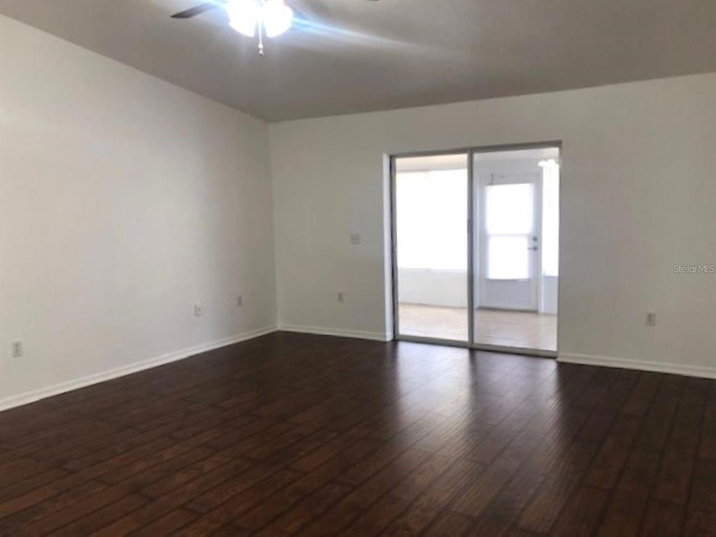4955 Southwest 129th Place Ocala, FL 34473 - Photo 10 of 19 a view of an empty room with wooden floor and a window