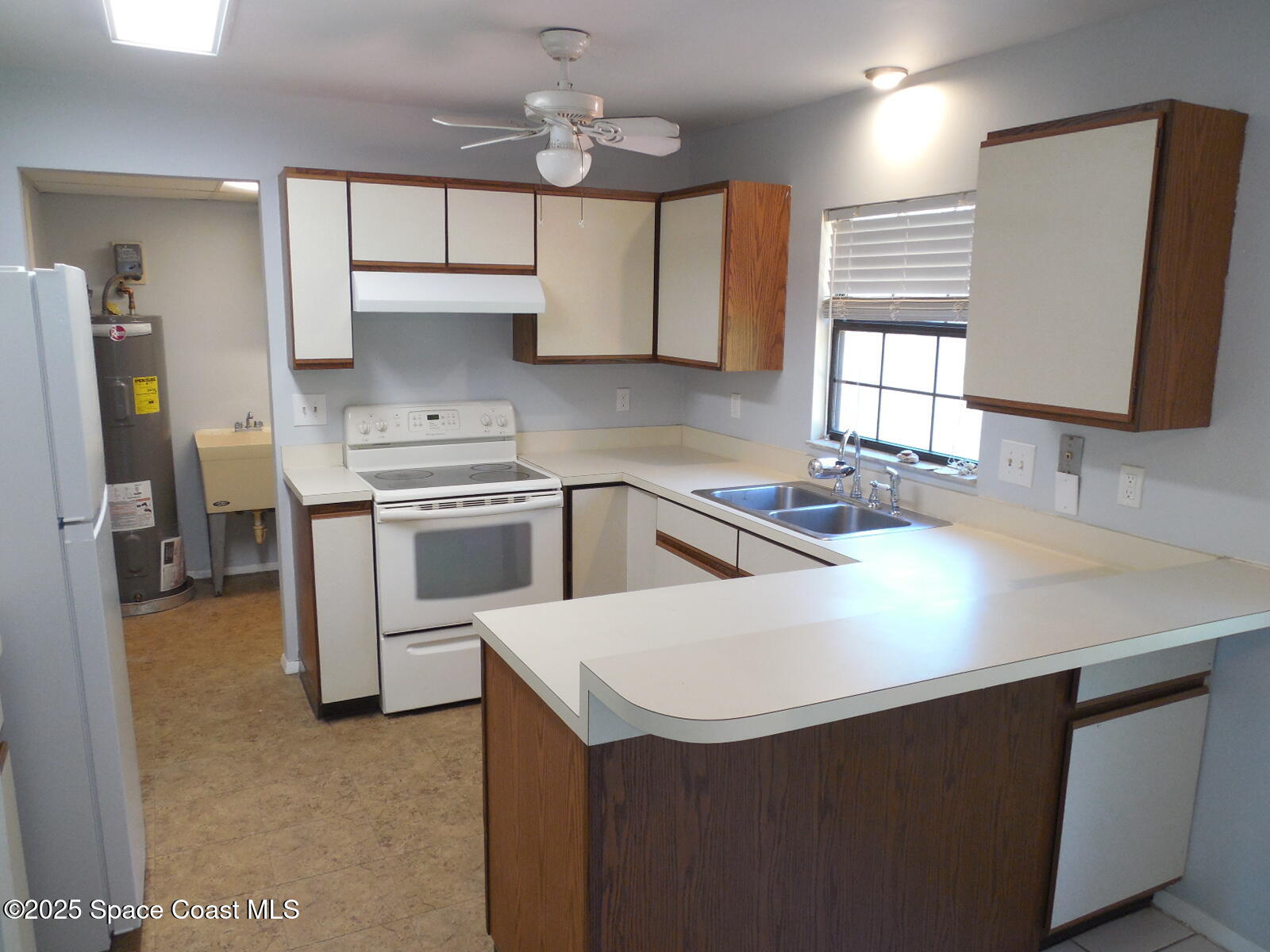 345 Ocean View Lane Indialantic, FL 32903 - Photo 4 of 31 a kitchen with stainless steel appliances a sink a stove a refrigerator cabinets and a window