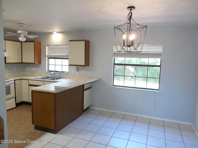a kitchen with a sink a counter space cabinets and appliances