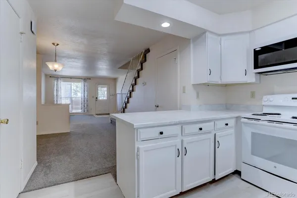 a kitchen with white cabinets and white appliances