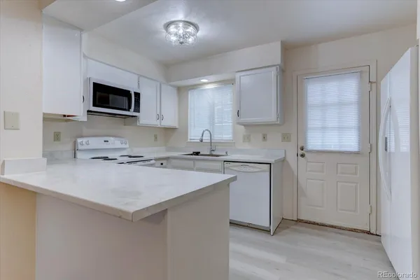 a kitchen with a sink stove and microwave