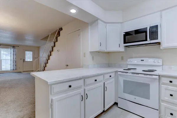 a kitchen with cabinets stainless steel appliances and wooden floor