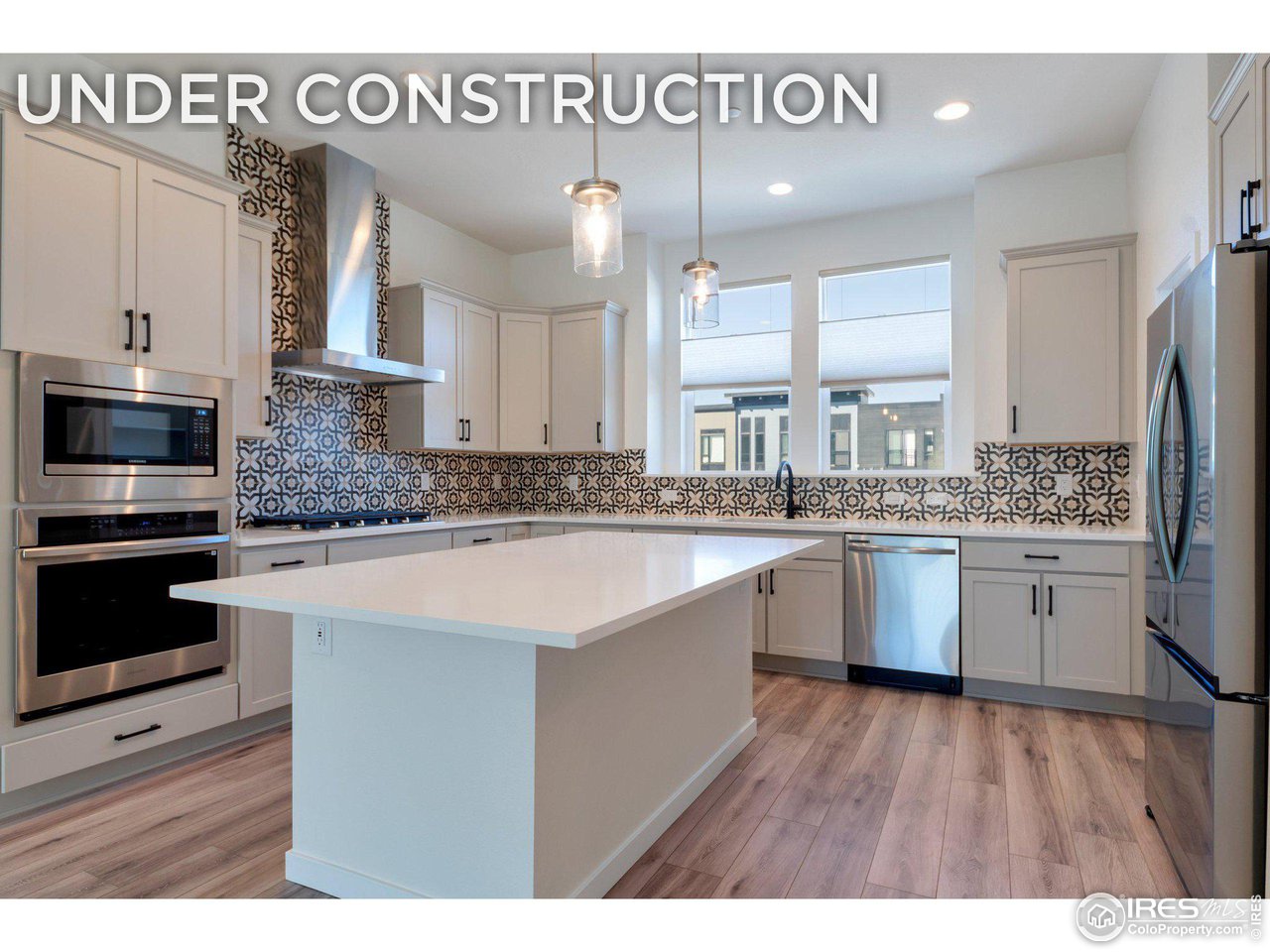 a large white kitchen with a sink and dishwasher a stove with wooden floor