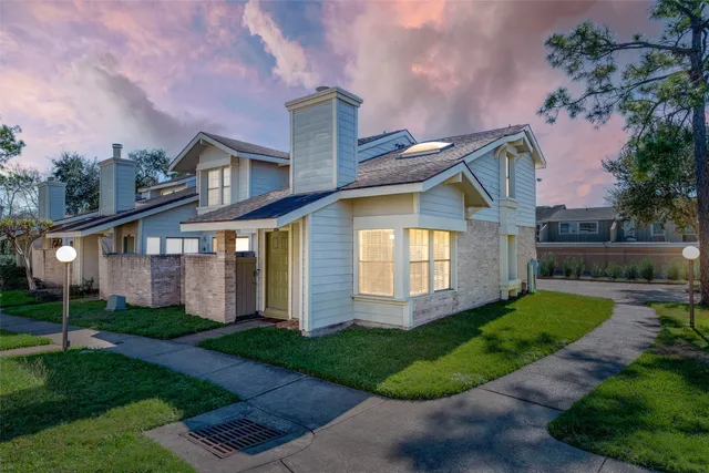 a front view of a house with a yard and trees