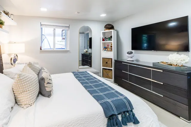 a bedroom with a bed and a flat screen tv