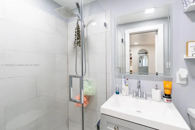 a bathroom with a sink vanity mirror and shower