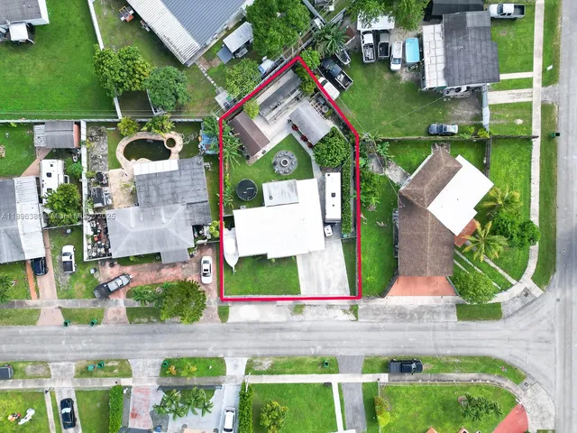 an aerial view of house with swimming pool and front yard