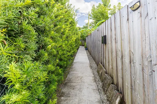 a view of a pathway of a garden with wooden fence