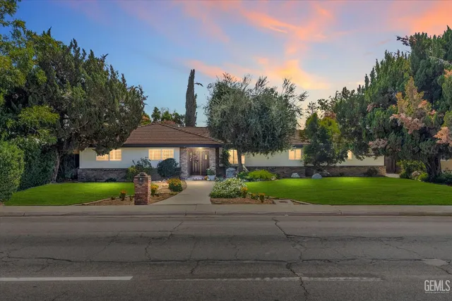a view of a park that has a table and chairs under an umbrella