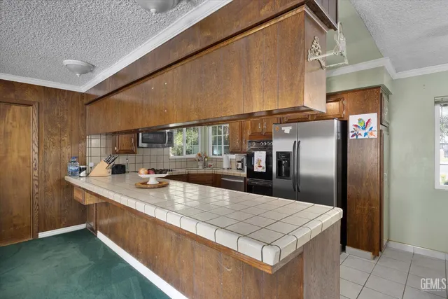 a kitchen with stainless steel appliances granite countertop a sink a stove and a refrigerator